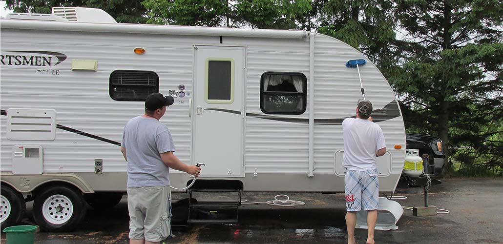 two men washing the exterior of a recreational vehicle